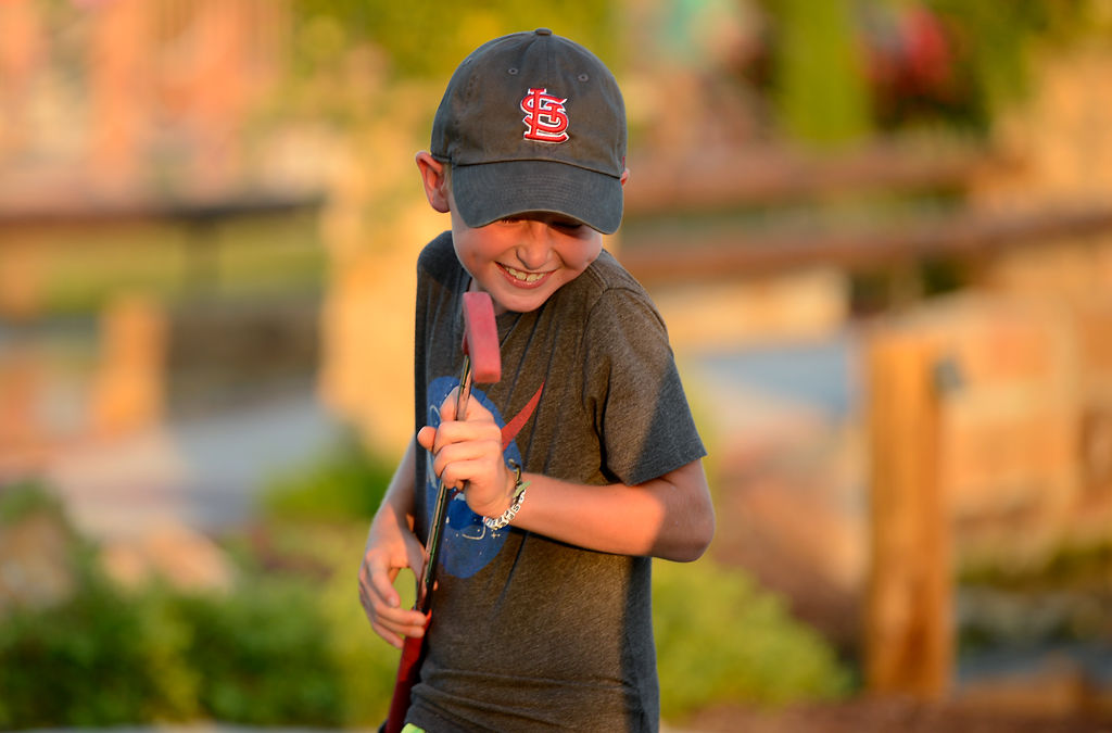 Asher Gray, 9, cheers over his mini golf shot